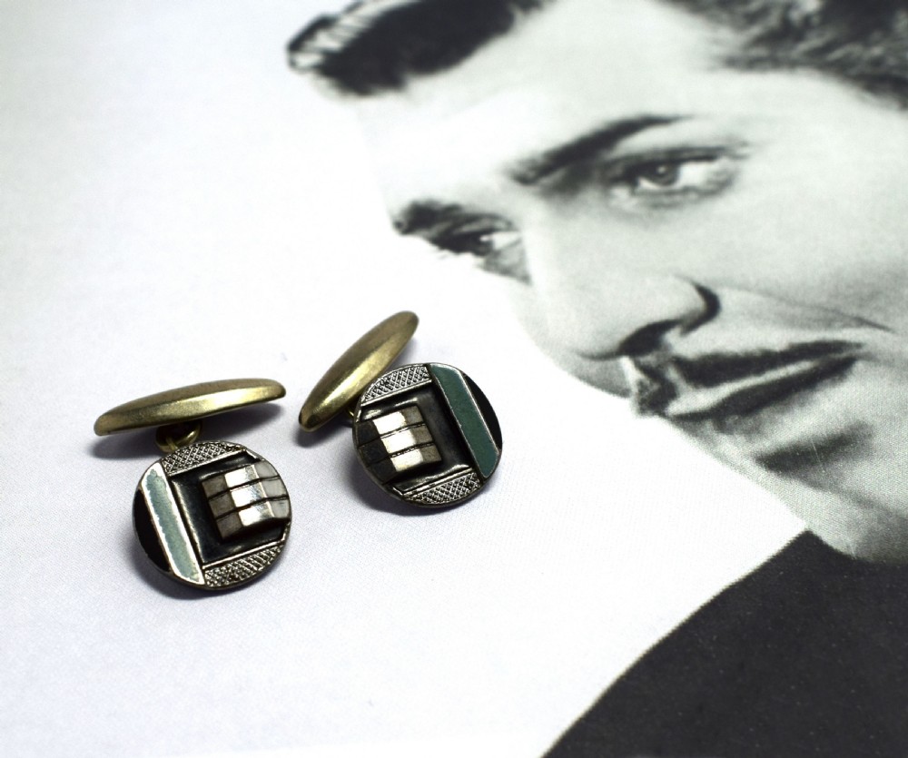 A pair of round Art Deco silver cufflinks decorated with black and light blue geometric enamel sections and raised stepped metal accents. View III
