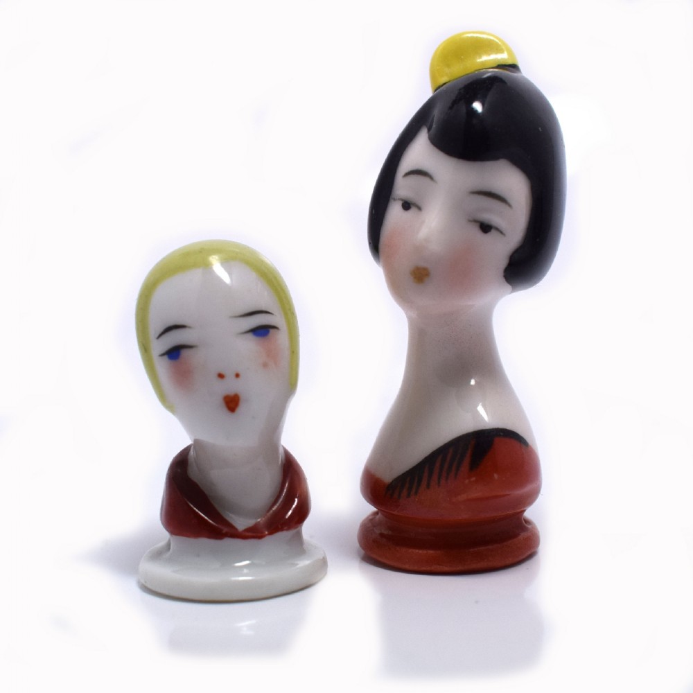 An Art Deco porcelain pincushion doll head featuring yellow bobbed hair, painted facial features, and a red collar. View IV