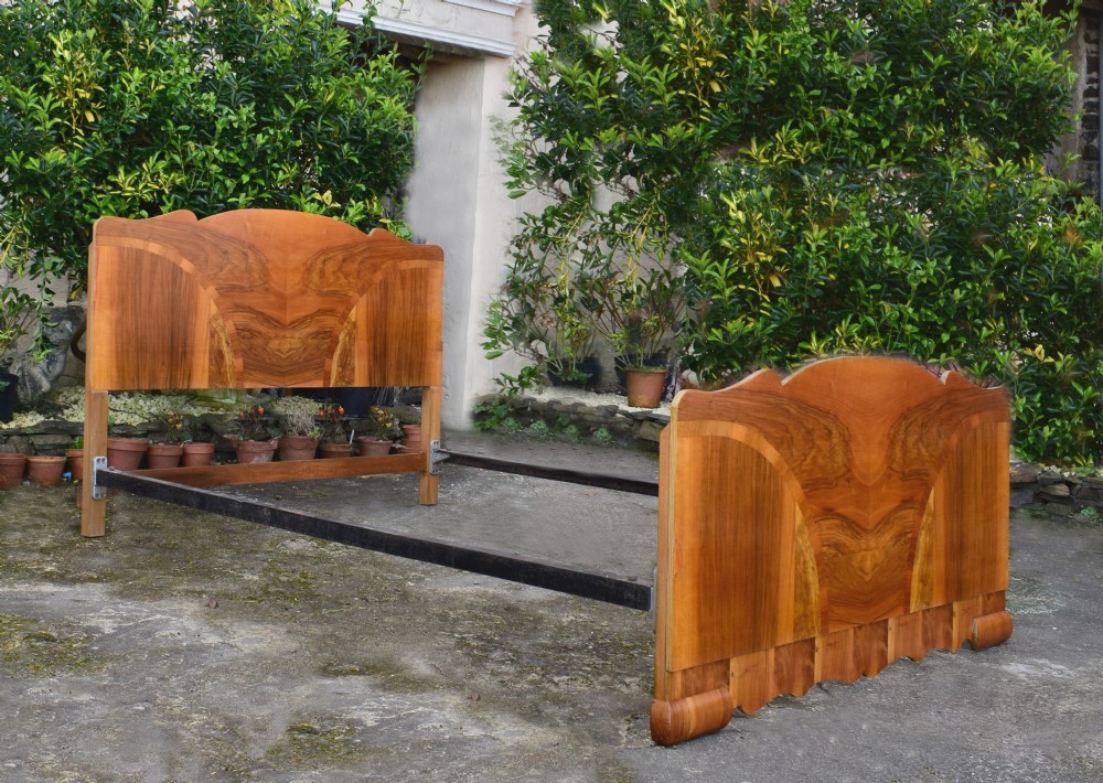 An Art Deco double bed frame featuring an arched cloud-shaped headboard and matching footboard with symmetrical book-matched walnut veneer. View IX