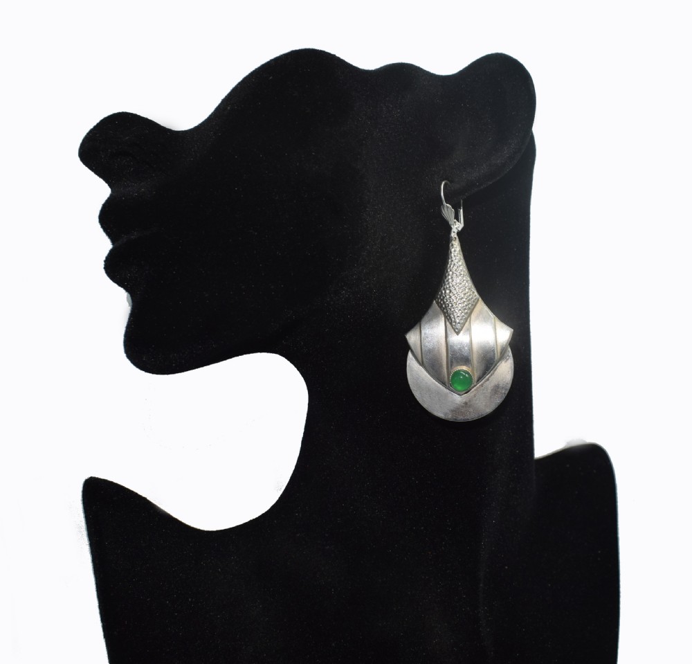 A pair of Art Deco style silver-plated drop earrings featuring geometric fan shapes, hammered detailing, and round green glass cabochons. View V