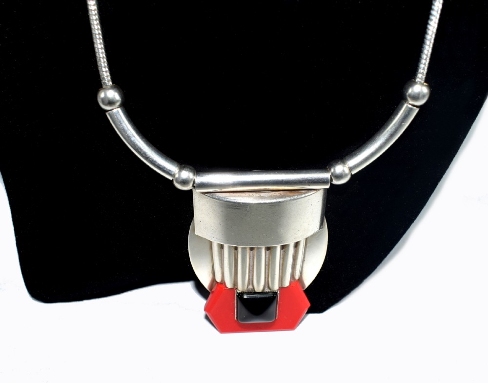 An Art Deco snake chain necklace featuring a geometric silver-tone pendant set with a red Galalith element and a central square black cabochon. View III