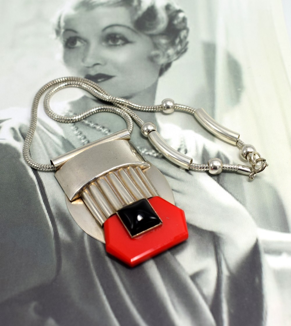 An Art Deco snake chain necklace featuring a geometric silver-tone pendant set with a red Galalith element and a central square black cabochon. View V