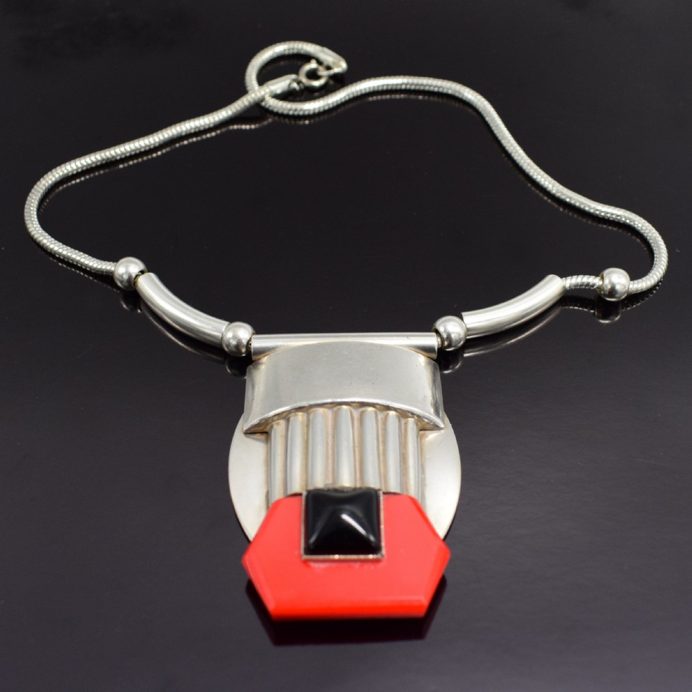 An Art Deco snake chain necklace featuring a geometric silver-tone pendant set with a red Galalith element and a central square black cabochon. View VI
