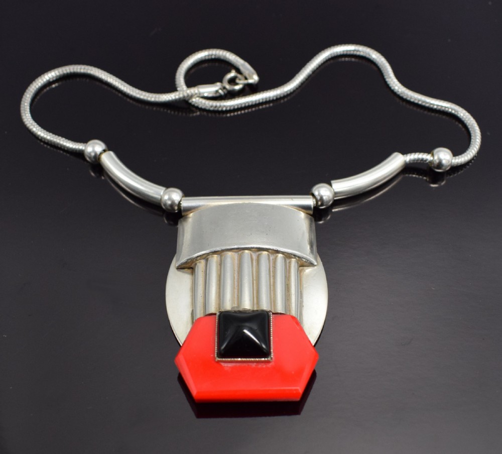 An Art Deco snake chain necklace featuring a geometric silver-tone pendant set with a red Galalith element and a central square black cabochon. View VII