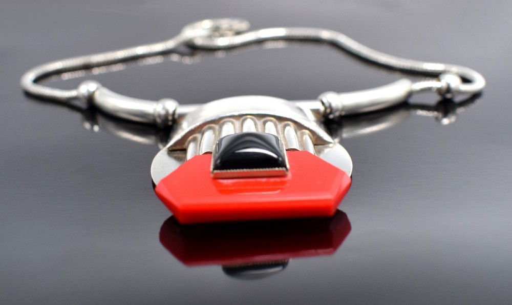 An Art Deco snake chain necklace featuring a geometric silver-tone pendant set with a red Galalith element and a central square black cabochon. View VIII