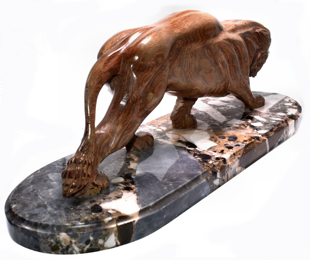 A stylised Art Deco sculpture of a prowling panther crafted from reddish-brown veined stone mounted on a variegated marble plinth. View II