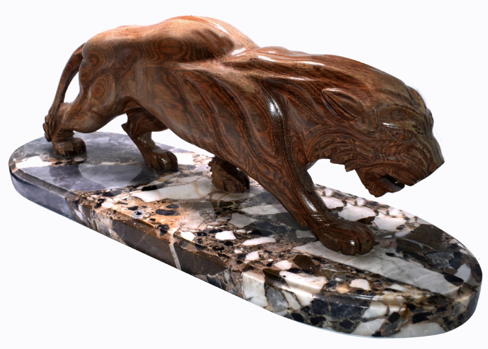 A stylised Art Deco sculpture of a prowling panther crafted from reddish-brown veined stone mounted on a variegated marble plinth. View III