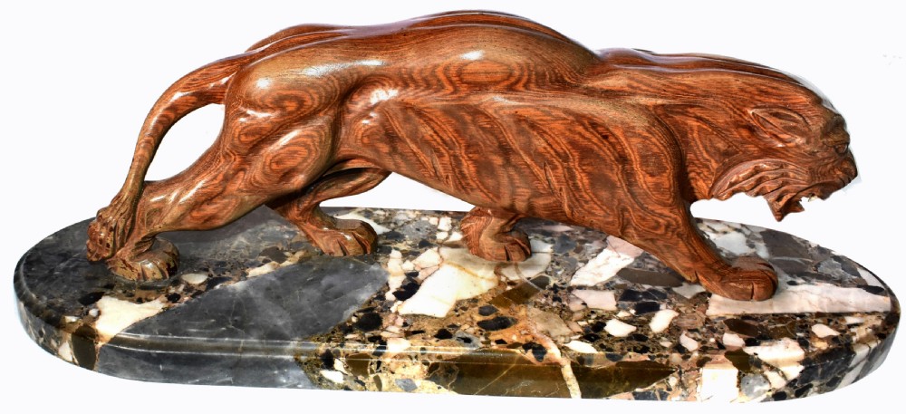 A stylised Art Deco sculpture of a prowling panther crafted from reddish-brown veined stone mounted on a variegated marble plinth. View VI