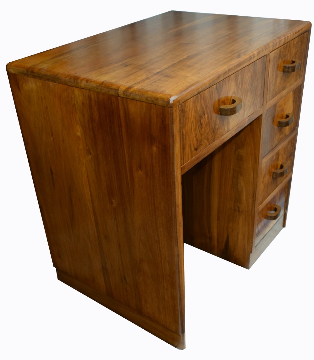 A 1930s Art Deco walnut writing desk featuring rounded corners, five drawers with wooden handles, and a kneehole section. View III