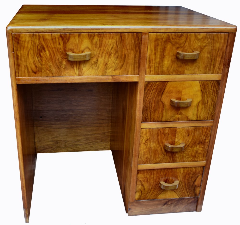 A 1930s Art Deco walnut writing desk featuring rounded corners, five drawers with wooden handles, and a kneehole section. View IV