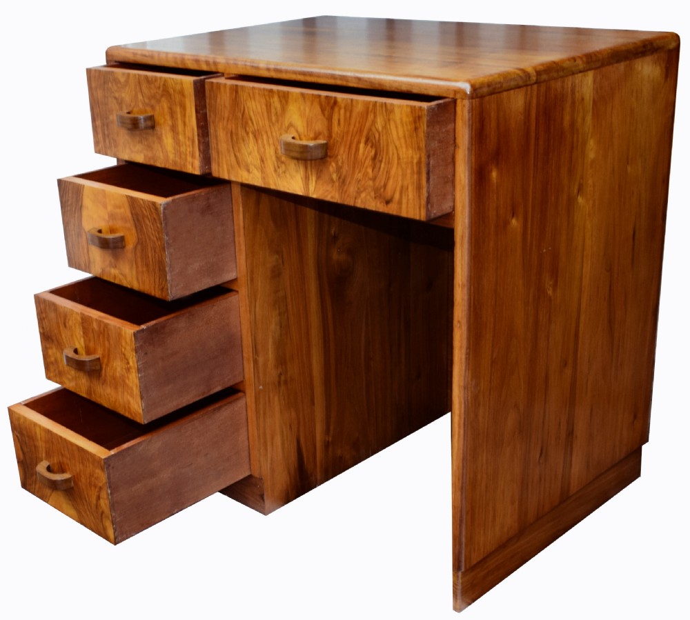 A 1930s Art Deco walnut writing desk featuring rounded corners, five drawers with wooden handles, and a kneehole section. View X