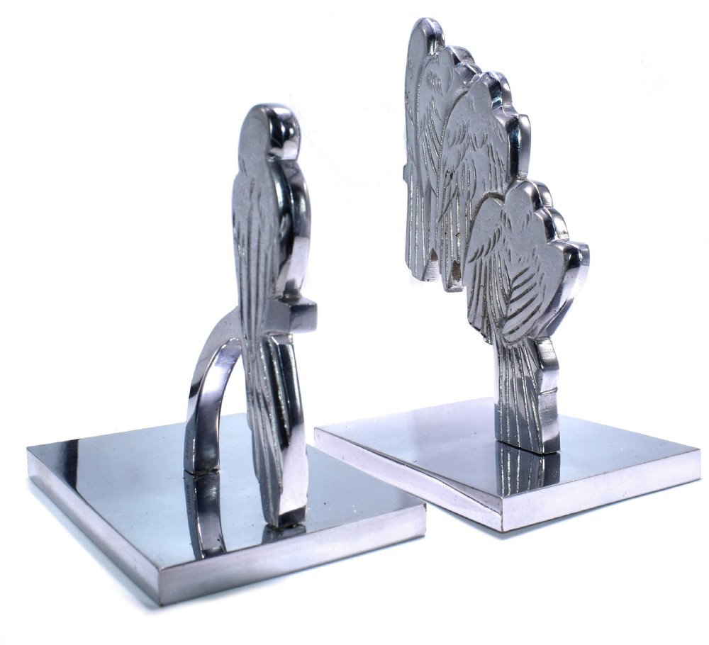 A pair of polished silver-coloured metal Art Deco bookends featuring stylised bird figures mounted on flat square bases. View III