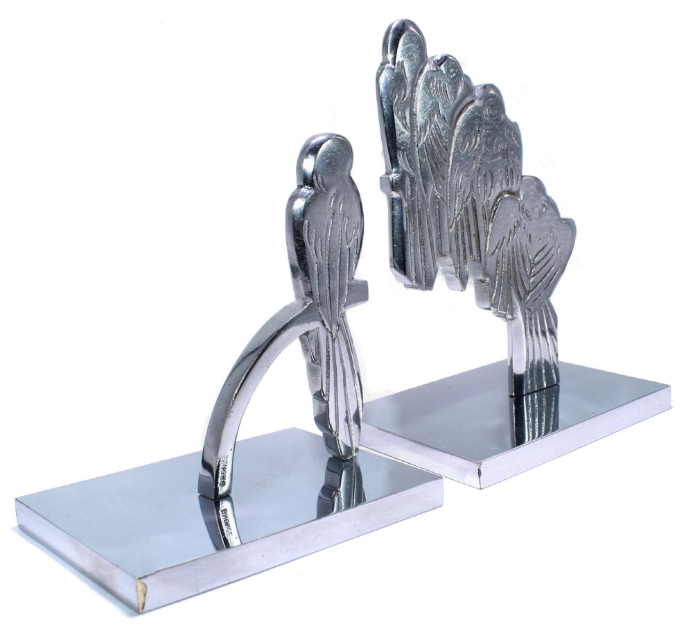 A pair of polished silver-coloured metal Art Deco bookends featuring stylised bird figures mounted on flat square bases. View VI