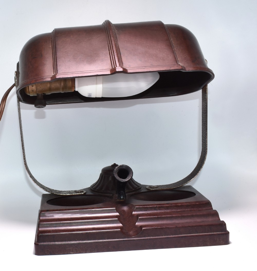 A dark brown mottled Bakelite desk lamp featuring a ribbed dome shade, curved metal arm, and an integrated pen tray base. View VII