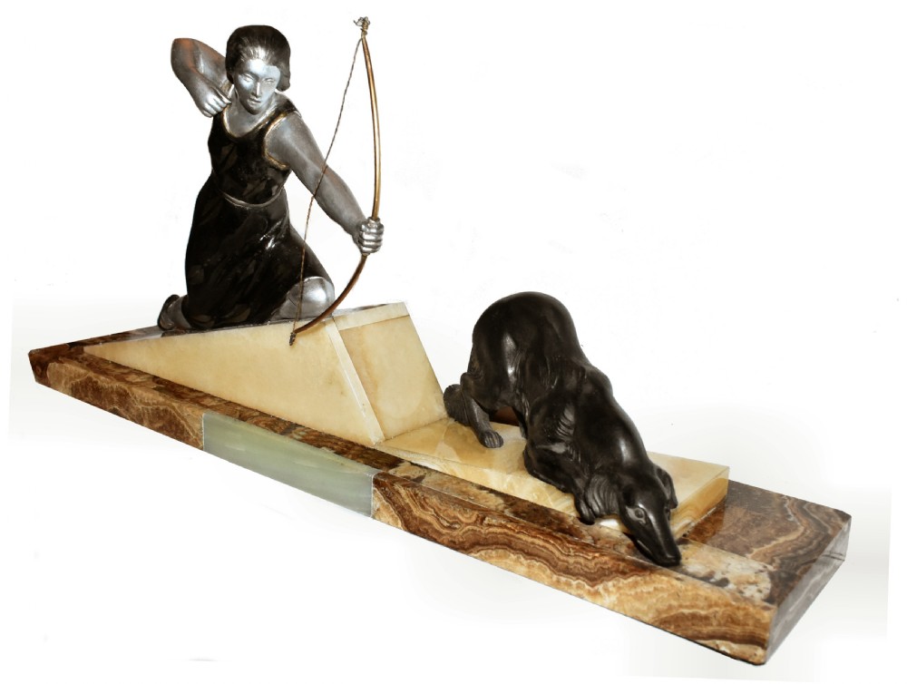 An Art Deco cold-painted metal sculpture depicting a female archer kneeling with a bow alongside a dog on a stepped onyx and marble base. View II