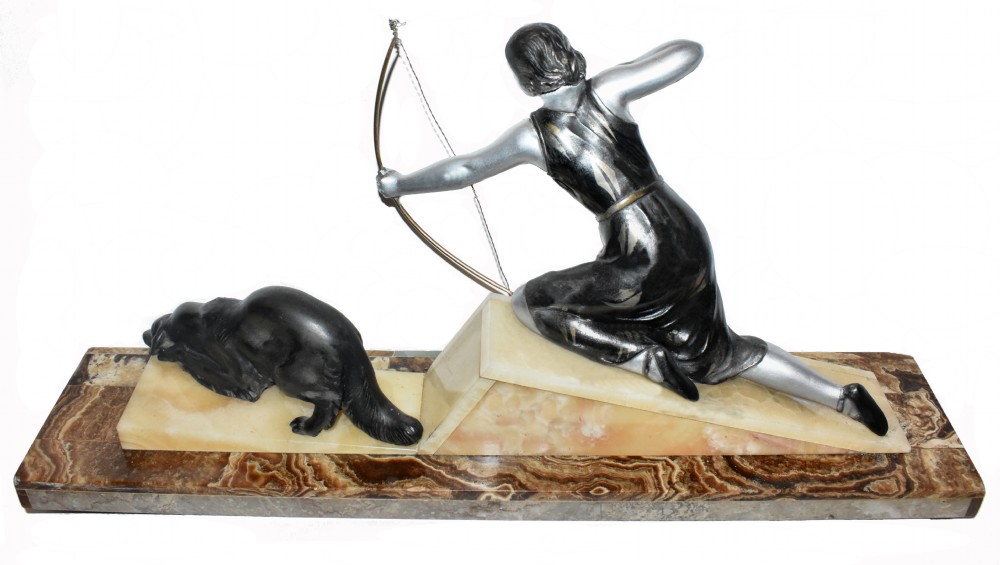An Art Deco cold-painted metal sculpture depicting a female archer kneeling with a bow alongside a dog on a stepped onyx and marble base. View III