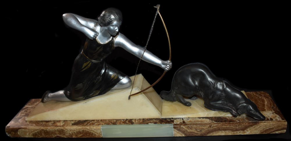 An Art Deco cold-painted metal sculpture depicting a female archer kneeling with a bow alongside a dog on a stepped onyx and marble base. View V
