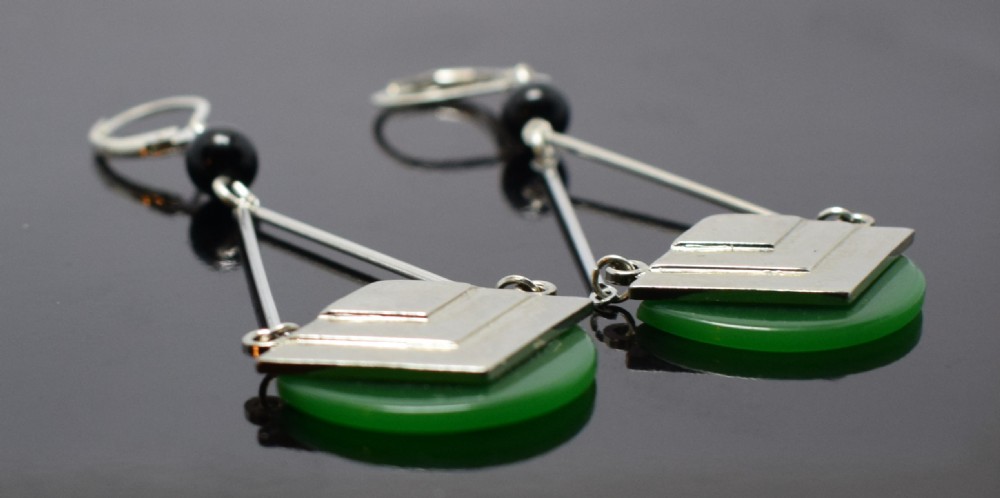 A pair of Art Deco drop earrings featuring green semicircular Bakelite disks topped with stepped geometric chrome motifs and lever-back hooks. View II