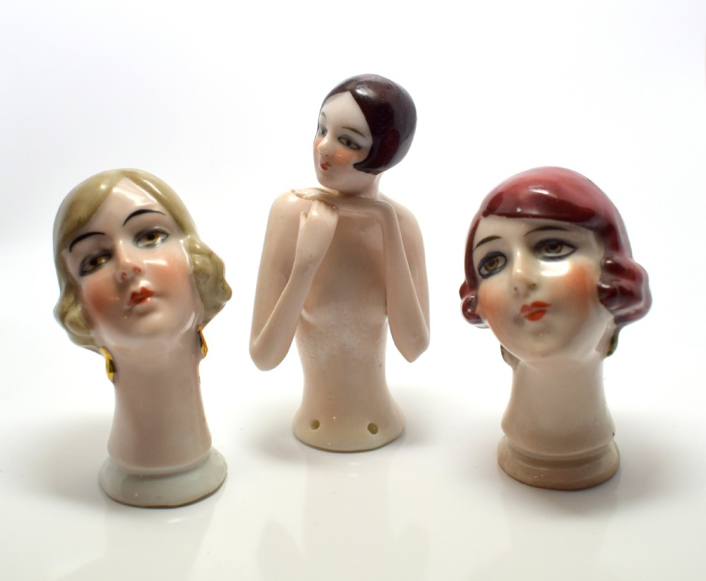 An Art Deco glazed porcelain half doll bust featuring a blonde bob haircut, stylized facial makeup, and a smooth neck base. View XI