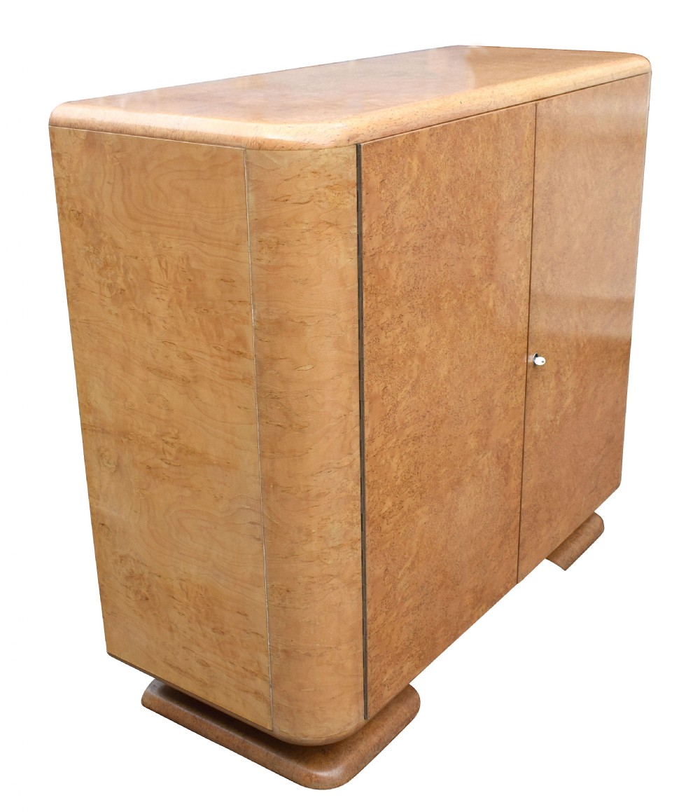 A two-door 1930s Art Deco bedroom cabinet featuring curved corners, figured blonde wood veneer, and low plinth feet. View II