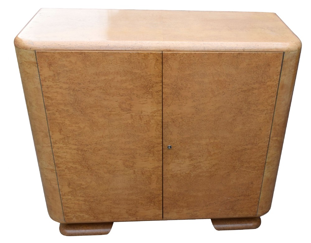 A two-door 1930s Art Deco bedroom cabinet featuring curved corners, figured blonde wood veneer, and low plinth feet. View VIII