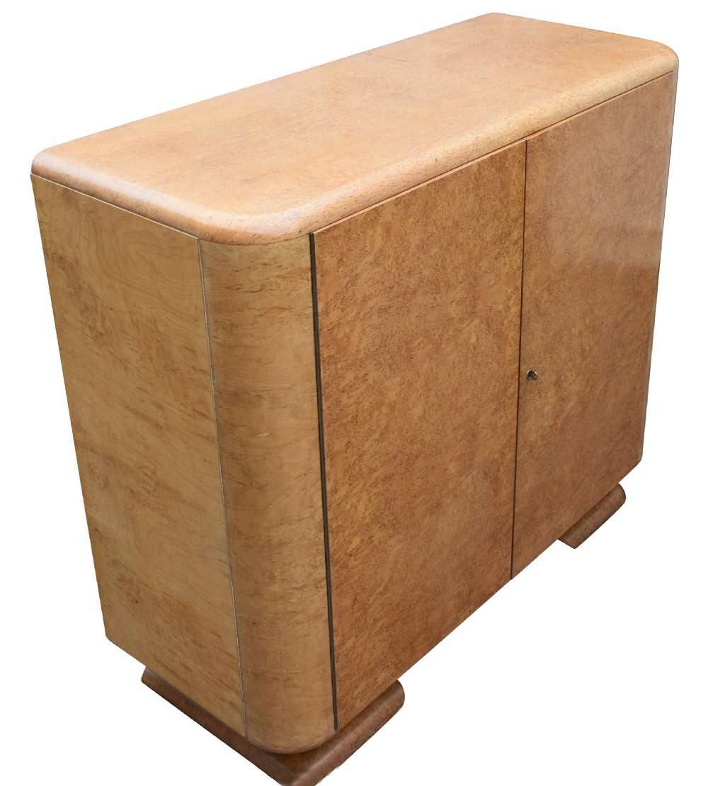A two-door 1930s Art Deco bedroom cabinet featuring curved corners, figured blonde wood veneer, and low plinth feet. View IX