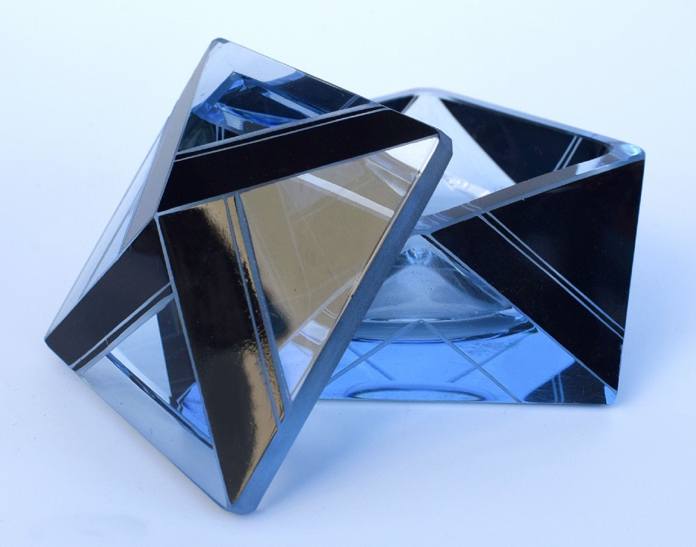 An Art Deco light blue glass vanity set consisting of a geometric scent bottle with a tall stopper and a matching powder box decorated with black triangular detailing. View IV