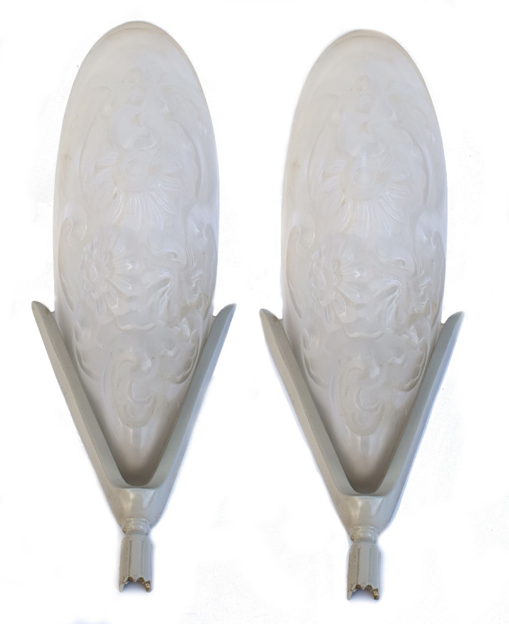 A matching pair of French Art Deco wall sconces featuring tapered frosted glass shades with raised floral relief patterns set into metal mounts.