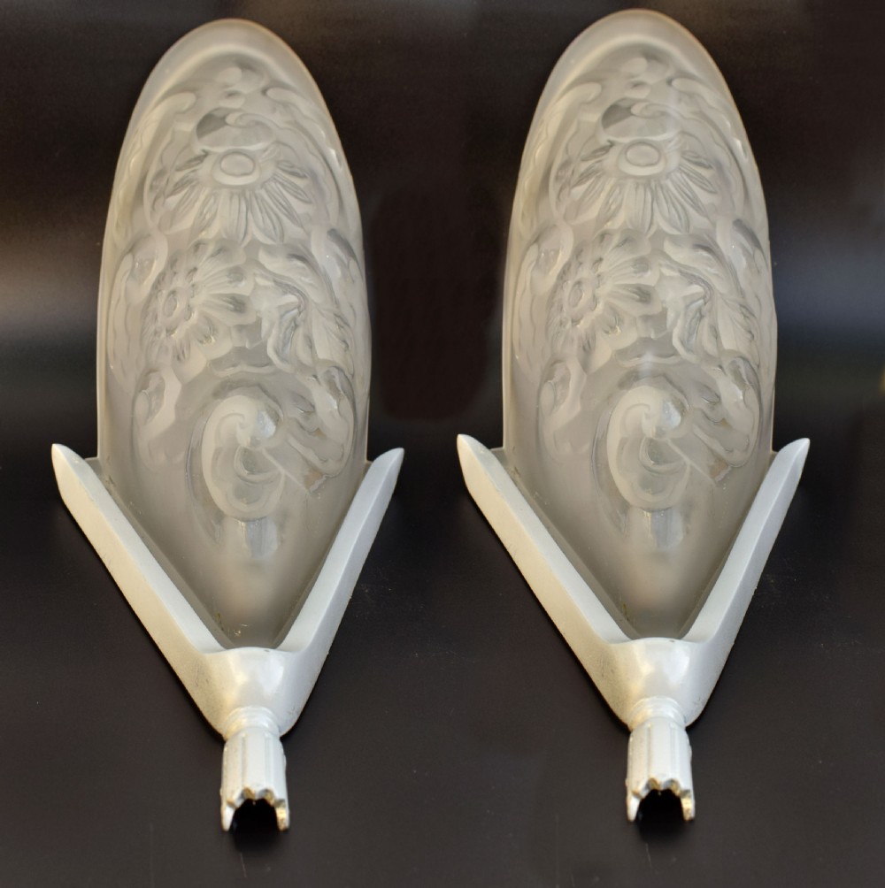 A matching pair of French Art Deco wall sconces featuring tapered frosted glass shades with raised floral relief patterns set into metal mounts. View II
