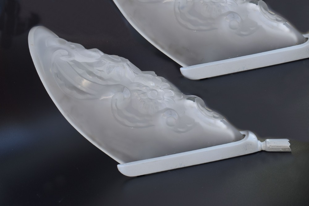 A matching pair of French Art Deco wall sconces featuring tapered frosted glass shades with raised floral relief patterns set into metal mounts. View III