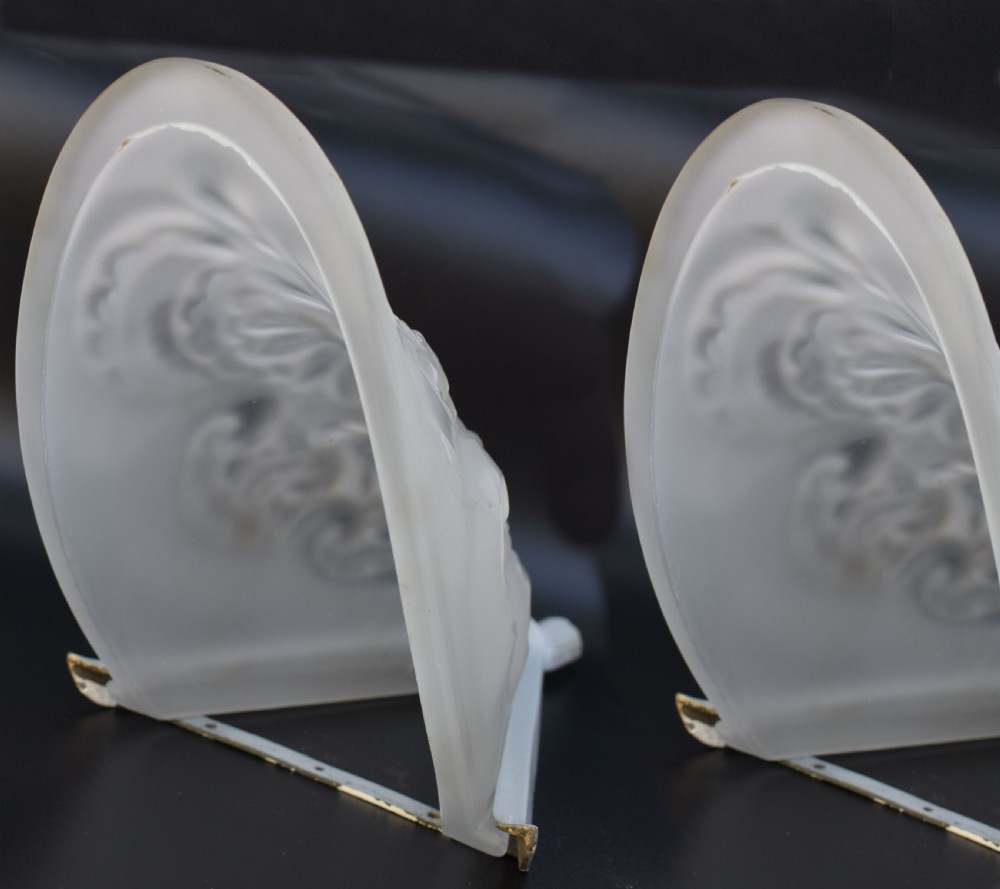 A matching pair of French Art Deco wall sconces featuring tapered frosted glass shades with raised floral relief patterns set into metal mounts. View IV