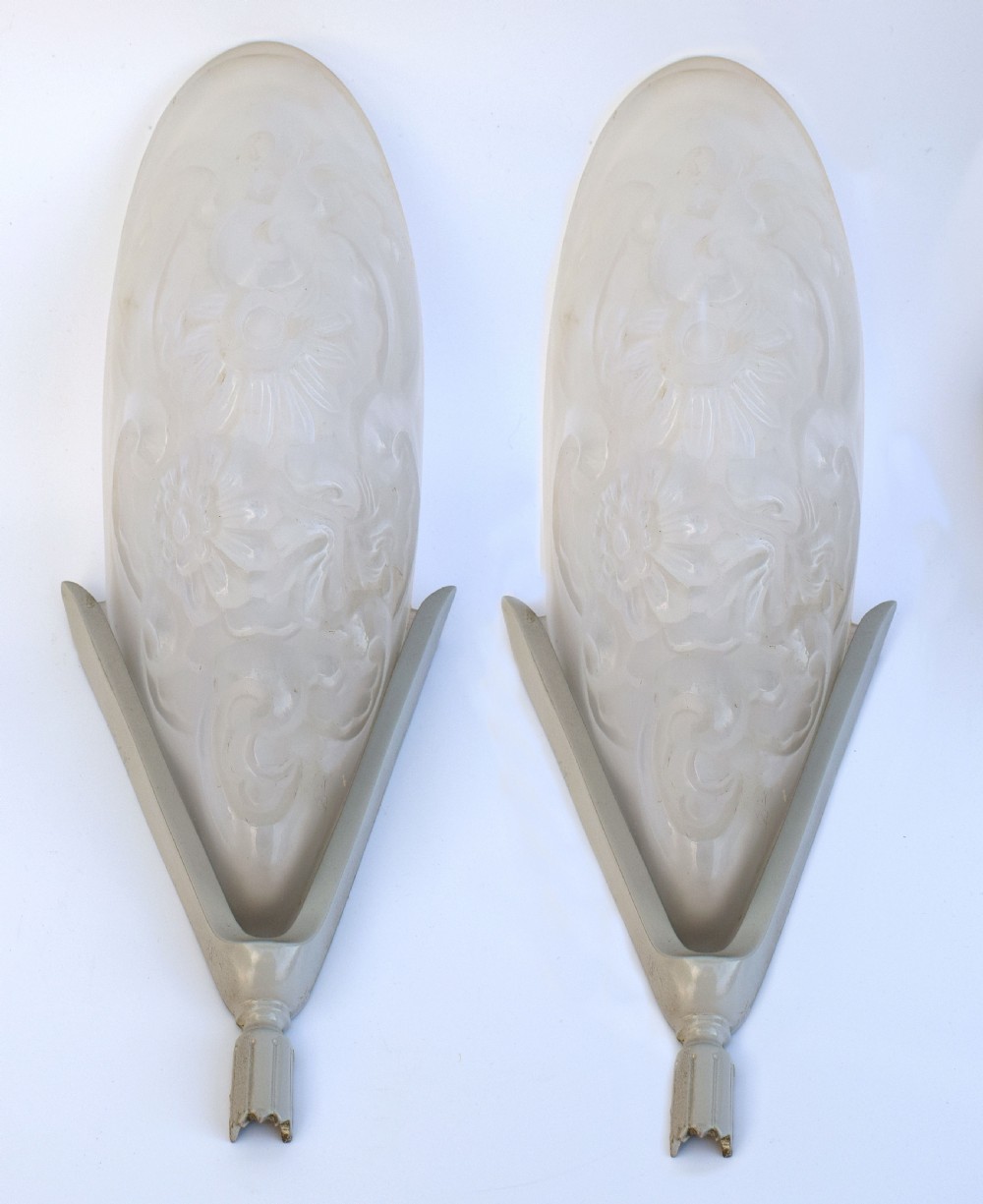 A matching pair of French Art Deco wall sconces featuring tapered frosted glass shades with raised floral relief patterns set into metal mounts. View VIII