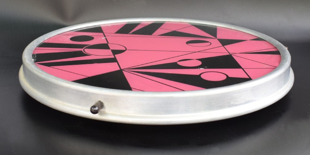A circular Art Deco Lazy Susan featuring a pink and black abstract geometric pattern encased within a silver metal rim. View II