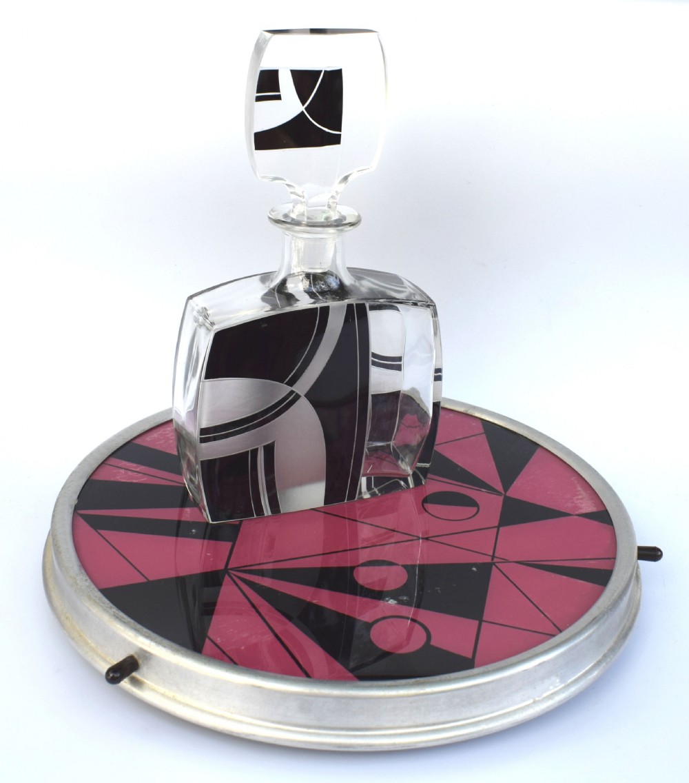 A circular Art Deco Lazy Susan featuring a pink and black abstract geometric pattern encased within a silver metal rim. View IV