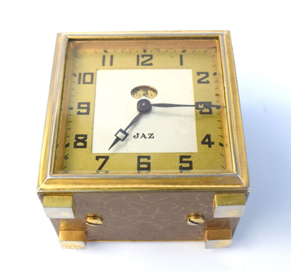 A square French Art Deco miniature alarm clock with a gilded brass casing and two-tone cream dial. View V
