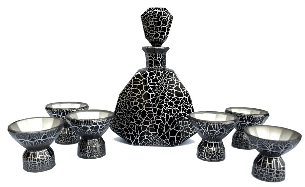 An Art Deco black and silver crackle-patterned glass decanter with six matching small cups arranged on a circular mirrored tray with wood handles. View VI