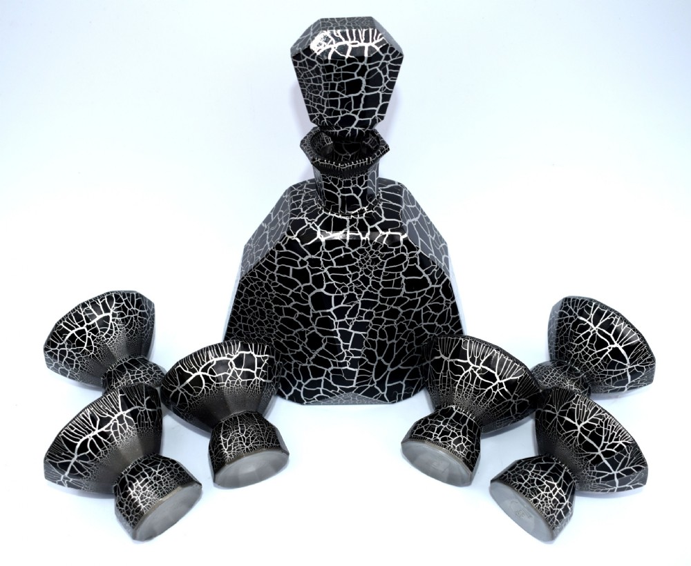 An Art Deco black and silver crackle-patterned glass decanter with six matching small cups arranged on a circular mirrored tray with wood handles. View VIII