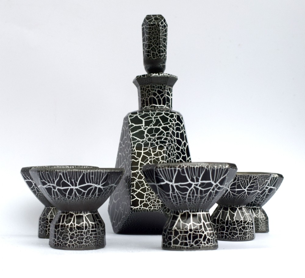 An Art Deco black and silver crackle-patterned glass decanter with six matching small cups arranged on a circular mirrored tray with wood handles. View XIII