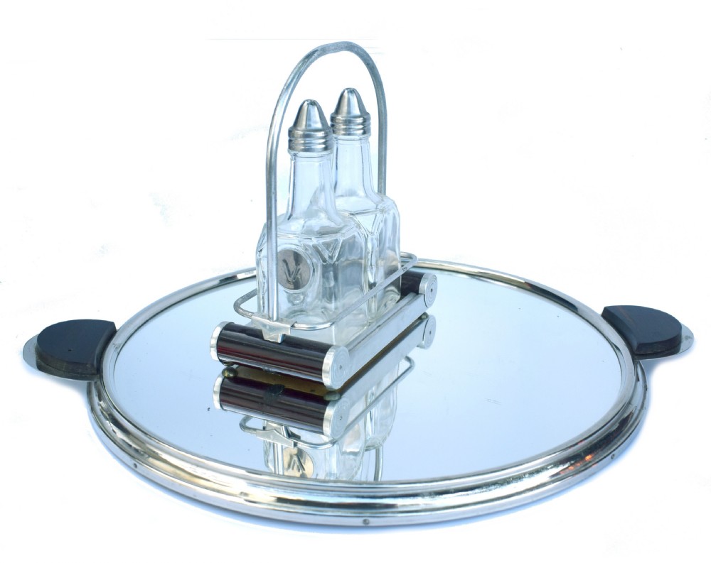 A pair of clear glass oil and vinegar bottles with silver metal tops marked V and O, housed in an Art Deco chrome carrying caddy. View II