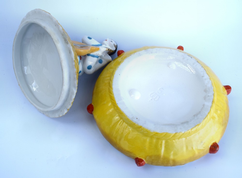 A yellow glazed porcelain powder bowl topped with a lid sculpted as a Pierrot character kneeling and playing a lute. View IV