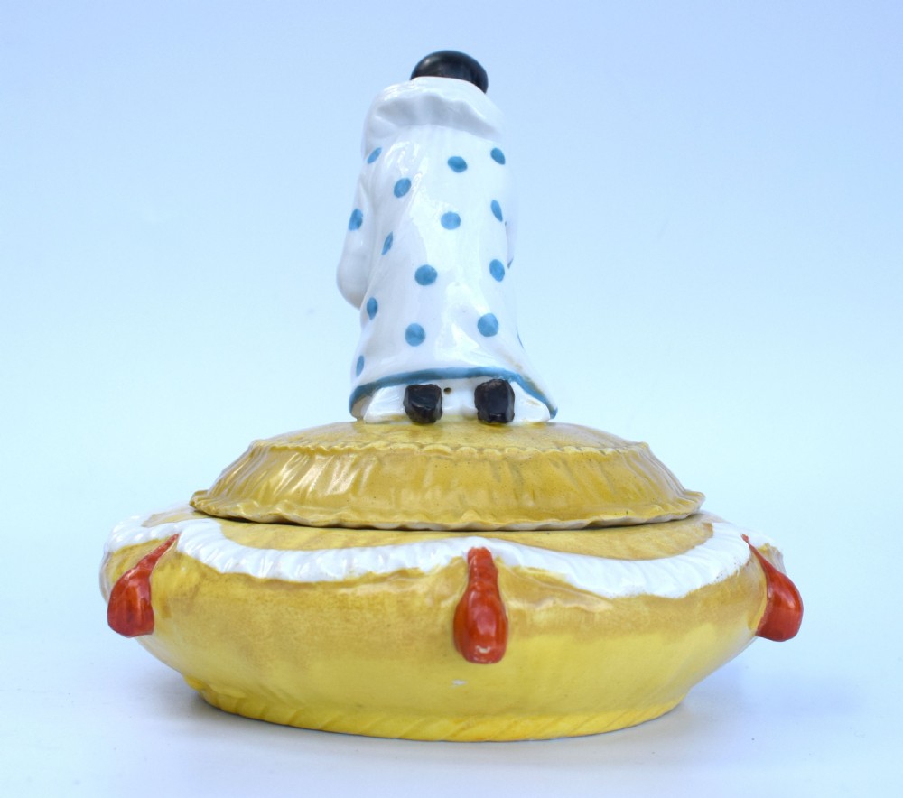 A yellow glazed porcelain powder bowl topped with a lid sculpted as a Pierrot character kneeling and playing a lute. View VI