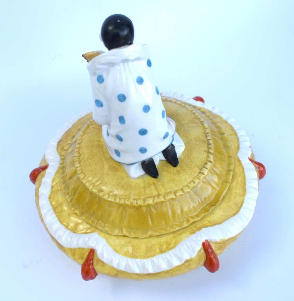 A yellow glazed porcelain powder bowl topped with a lid sculpted as a Pierrot character kneeling and playing a lute. View VII