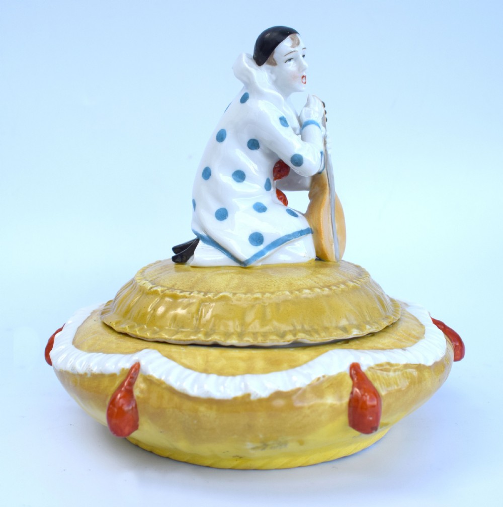 A yellow glazed porcelain powder bowl topped with a lid sculpted as a Pierrot character kneeling and playing a lute. View VIII