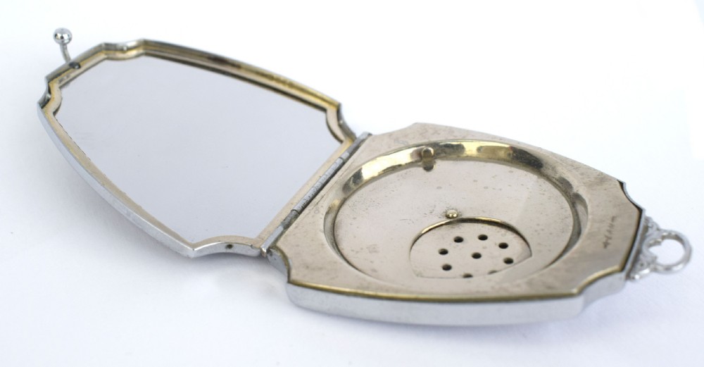 An Art Deco fan-shaped chrome powder compact with geometric blue, light blue, and black enamel panels and engine-turned metal details. View V