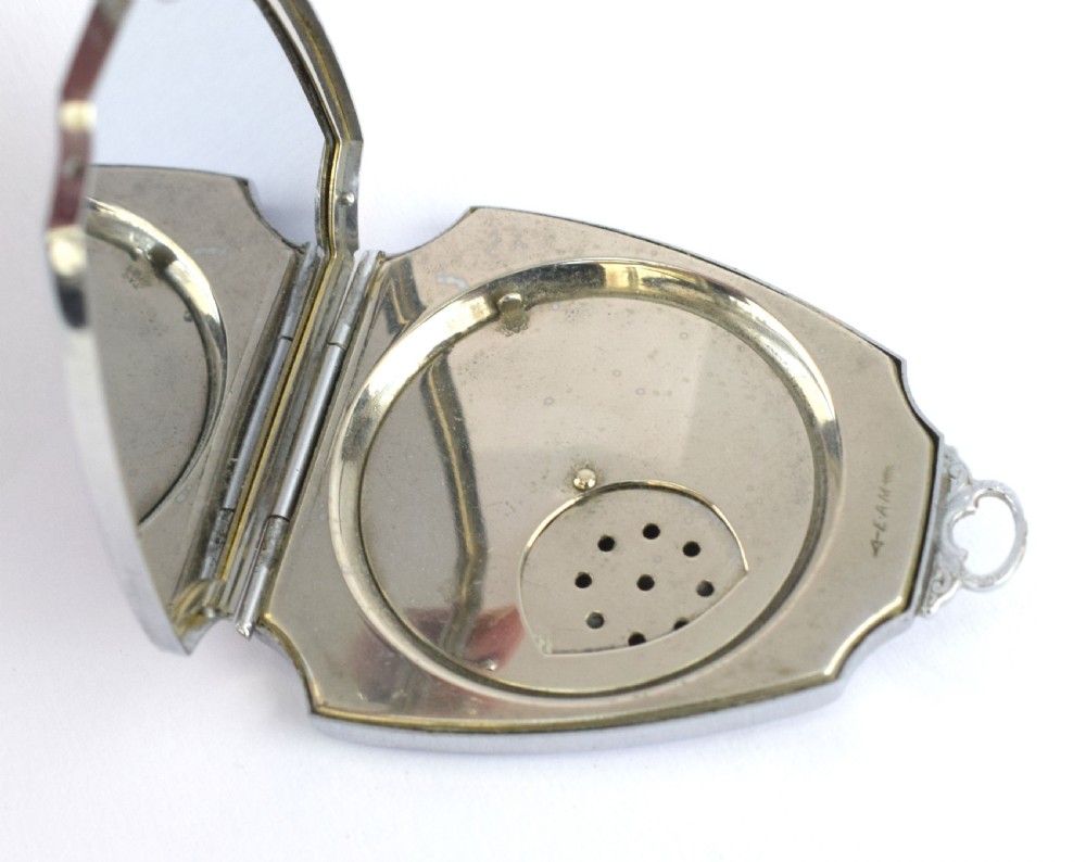 An Art Deco fan-shaped chrome powder compact with geometric blue, light blue, and black enamel panels and engine-turned metal details. View VI