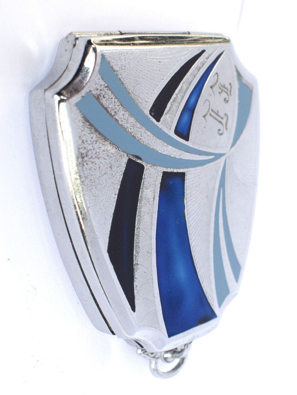 An Art Deco fan-shaped chrome powder compact with geometric blue, light blue, and black enamel panels and engine-turned metal details. View VII