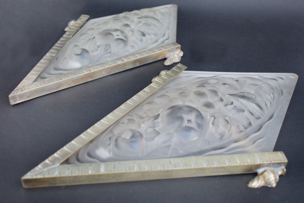 A pair of diamond-shaped Art Deco wall sconces featuring frosted glass with fruit relief designs held in incised bronze mounts. View V