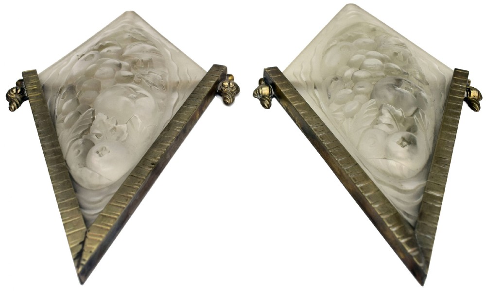 A pair of diamond-shaped Art Deco wall sconces featuring frosted glass with fruit relief designs held in incised bronze mounts. View X
