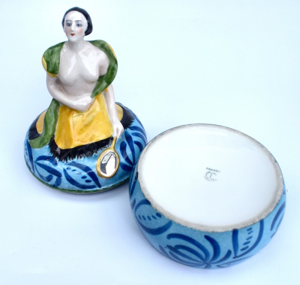 An Art Deco French Limoges glazed porcelain powder box featuring a lidded base with blue abstract pattern topped by a stylised female figure. View V