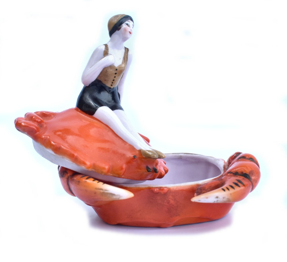 An Art Deco porcelain novelty powder bowl shaped as an orange crab with a bathing belle figure seated on its shell. View V